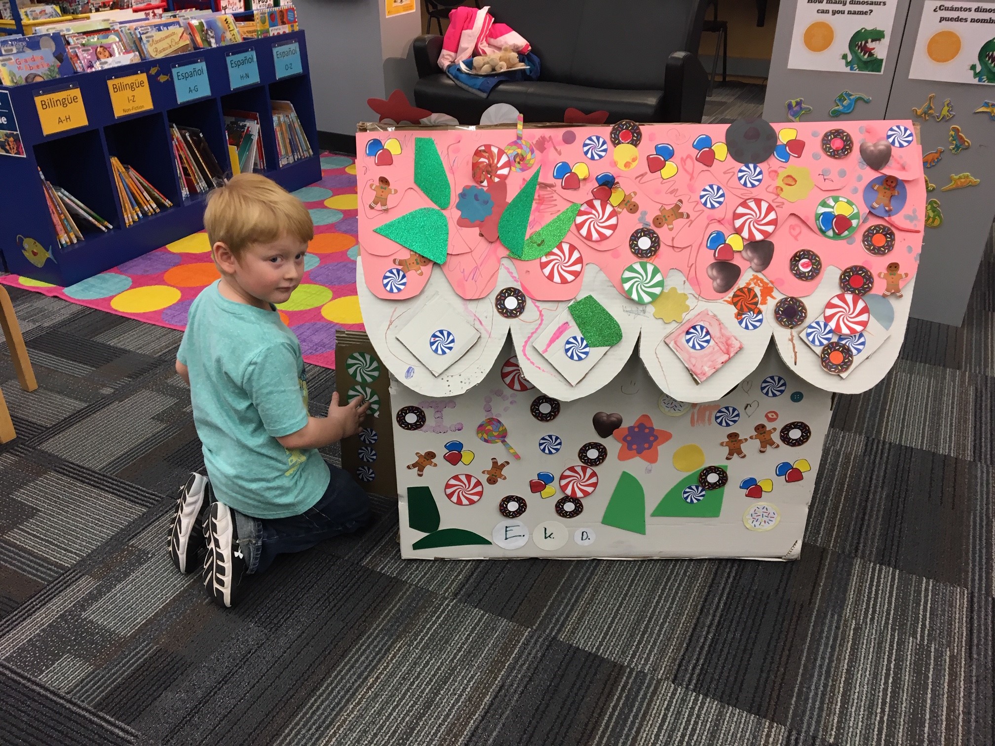 A child decorating a large Gingerbread house