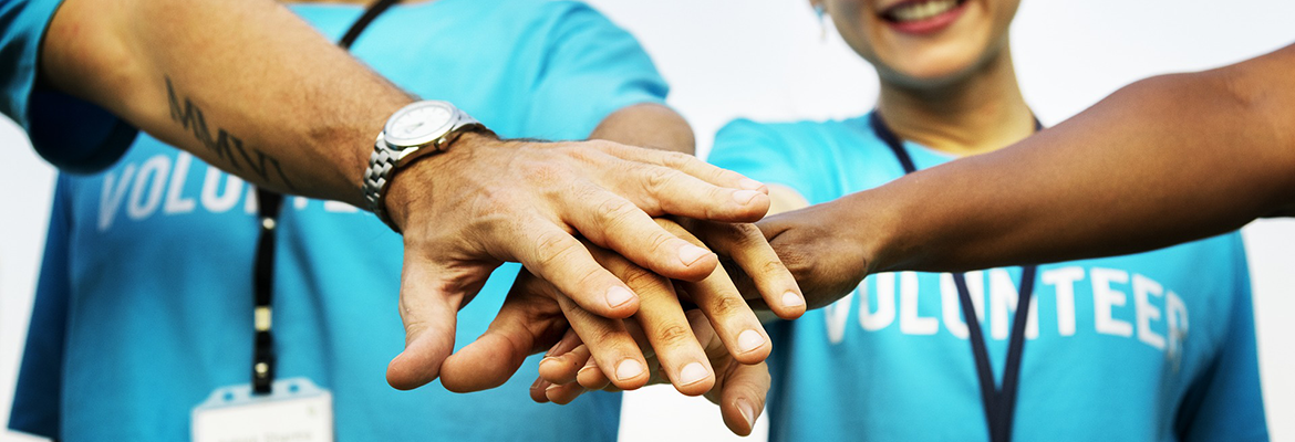 Volunteers stacking their hands after accomplishing something