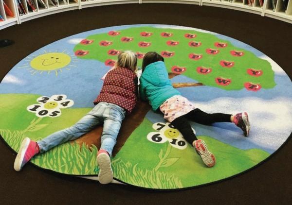Kids reading on colorful rug at Central
