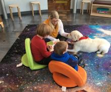 A group reads to a therapy dog during a "Furry Tales" session.