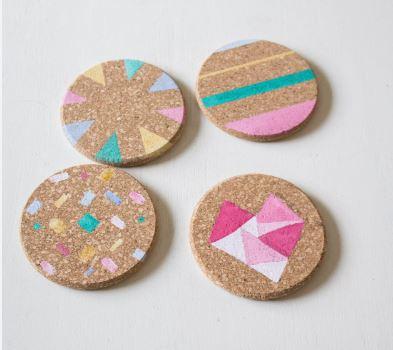 Round cork coasters with pastel painted designs on them.