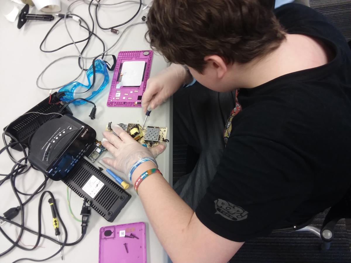 This is a person taking apart electronics.